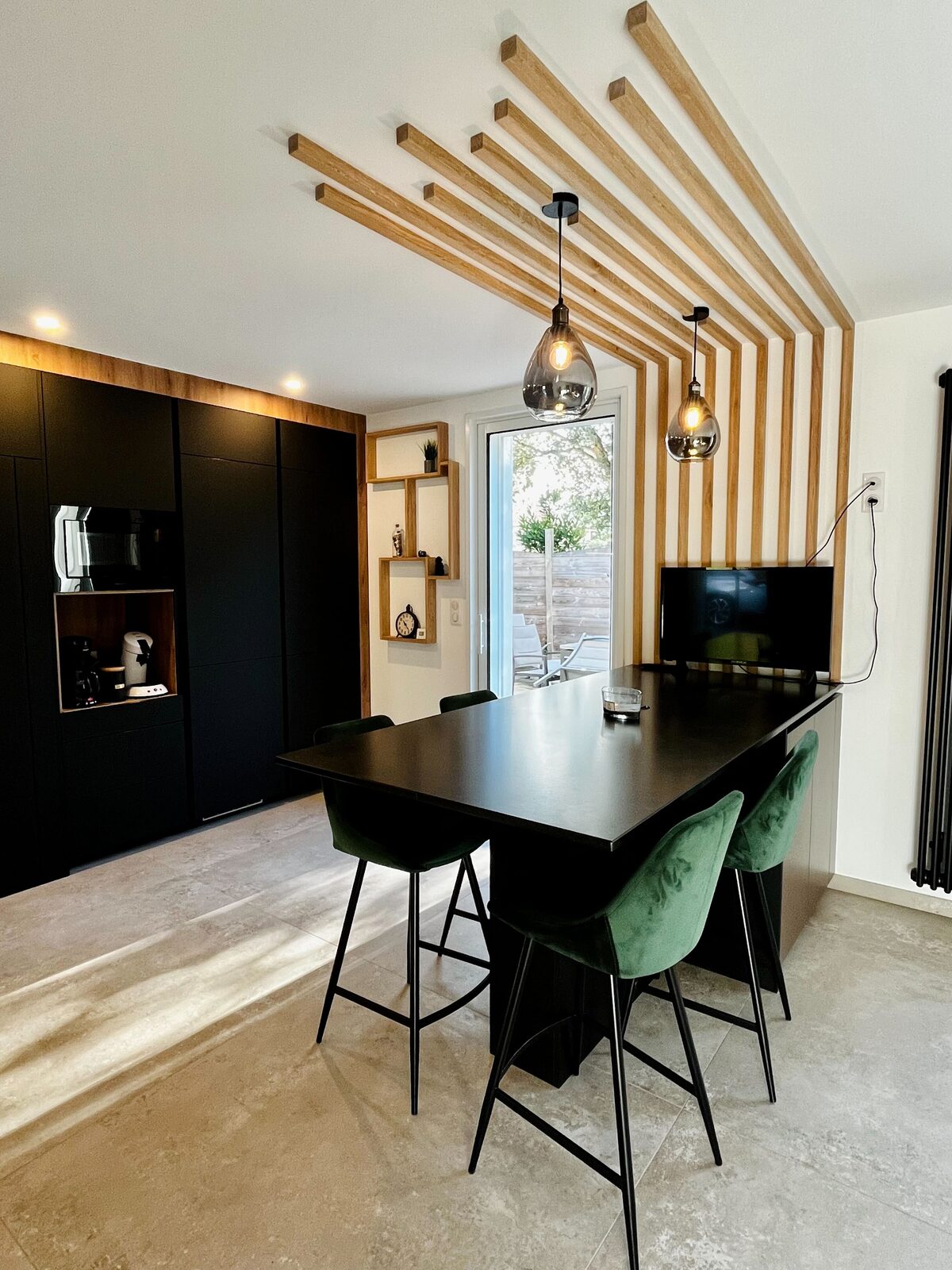 Cuisine noire et coin repas, plafond à tasseaux
